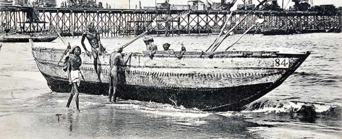 Historic view of the Madras Screw-Pile Iron Harbour with Masula boats ferrying passengers and cargo from offshore ships during the British era.
